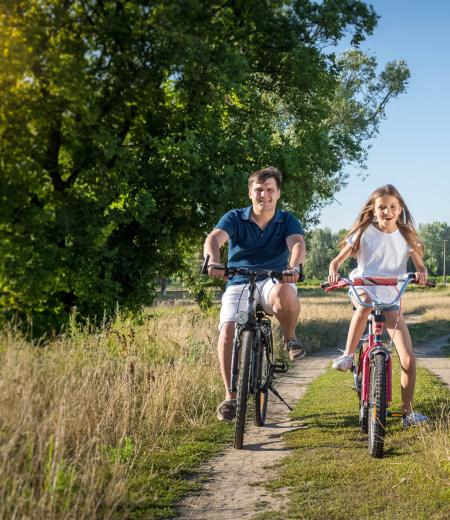 Famiglia in bicicletta su un sentiero di campagna.