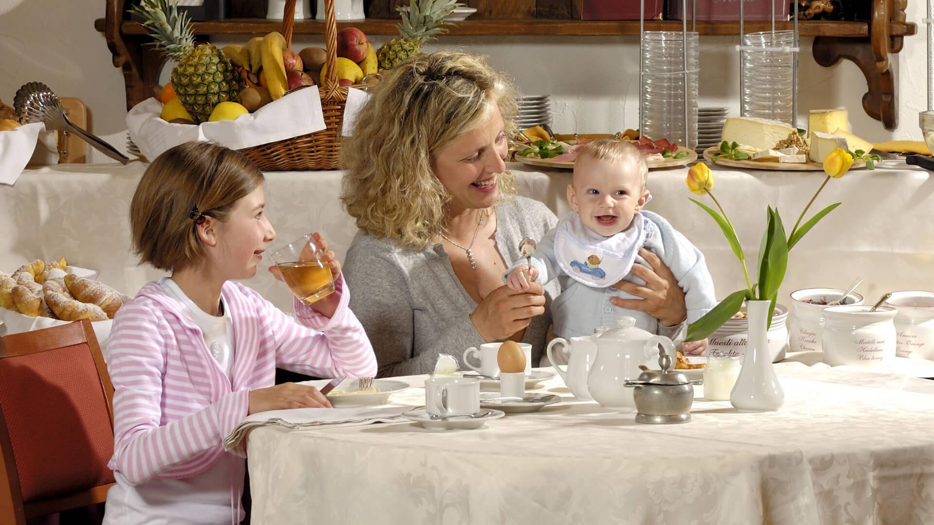 Una famiglia felice fa colazione insieme in un ristorante con cibo fresco e sorrisi.