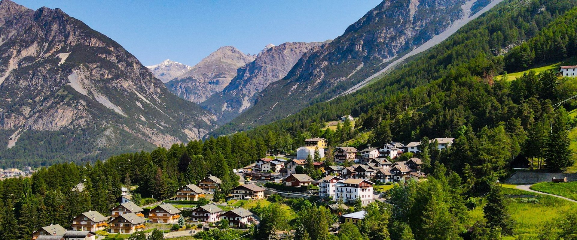 Un pittoresco villaggio di montagna circondato da verdi foreste e imponenti montagne.