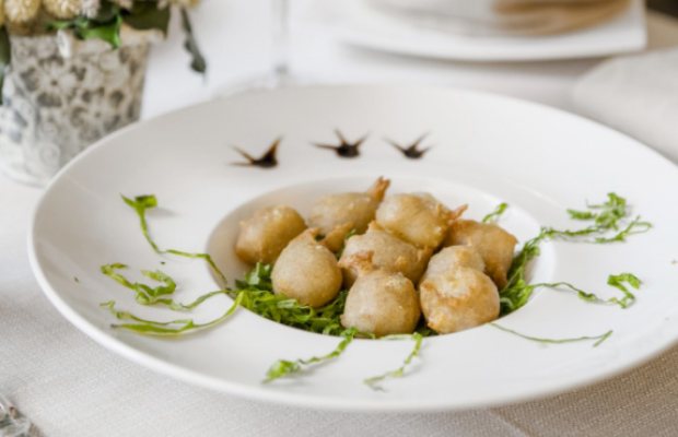 Piatto di pasta con salsa cremosa, decorato con erbe fresche.