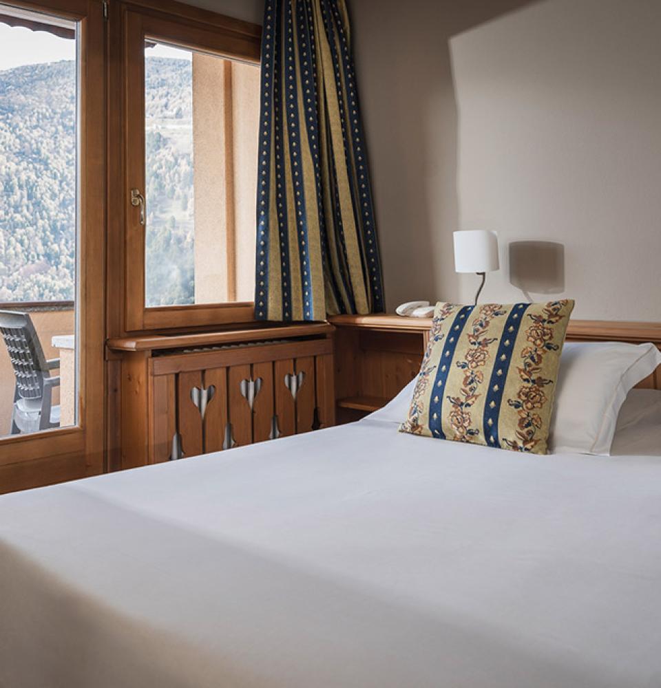 Chambre accueillante avec vue sur la montagne et coussins décoratifs.