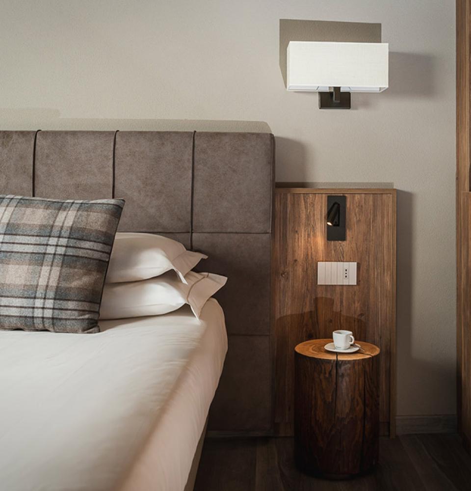 Chambre moderne avec coussin à carreaux et tasse sur table d'appoint.