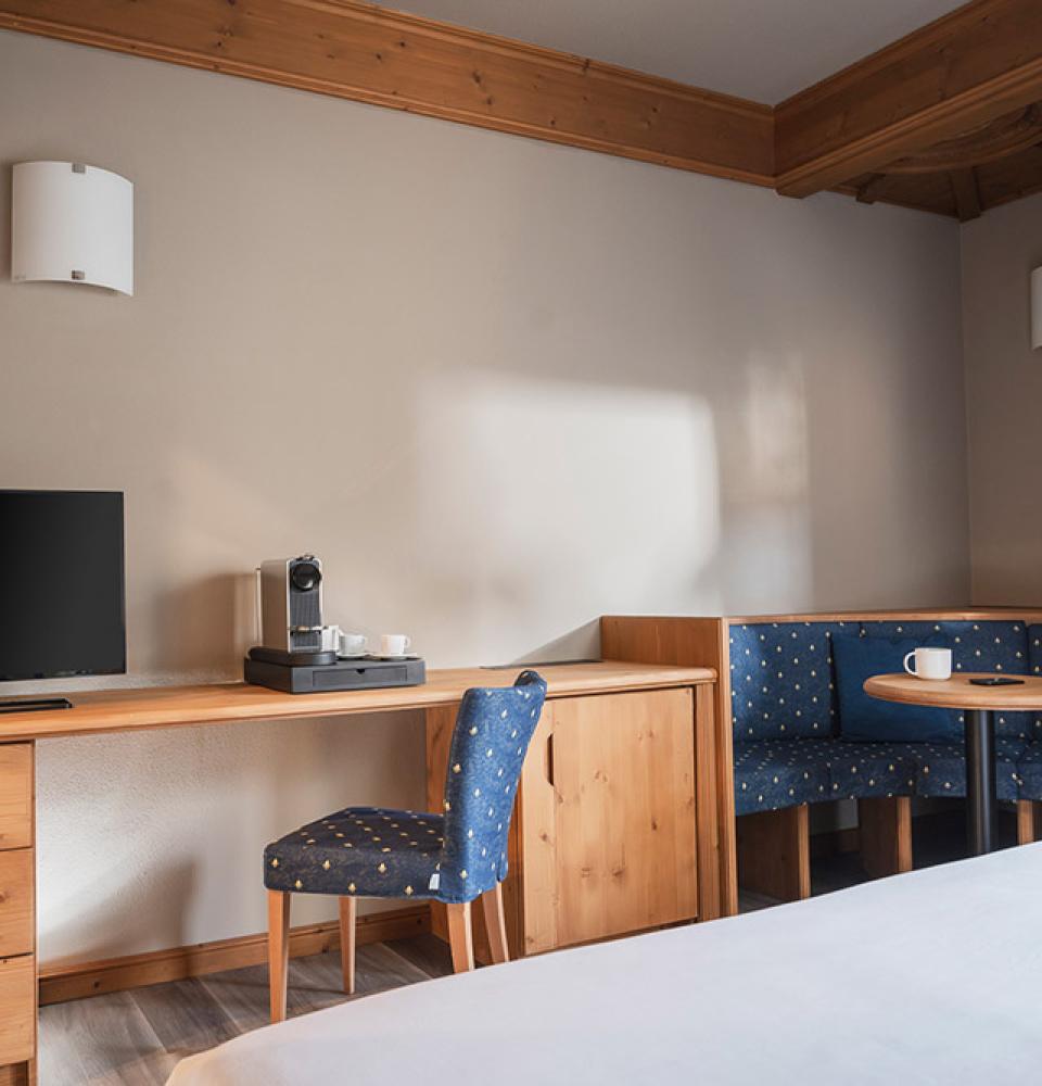 Chambre avec TV, bureau et coin salon.