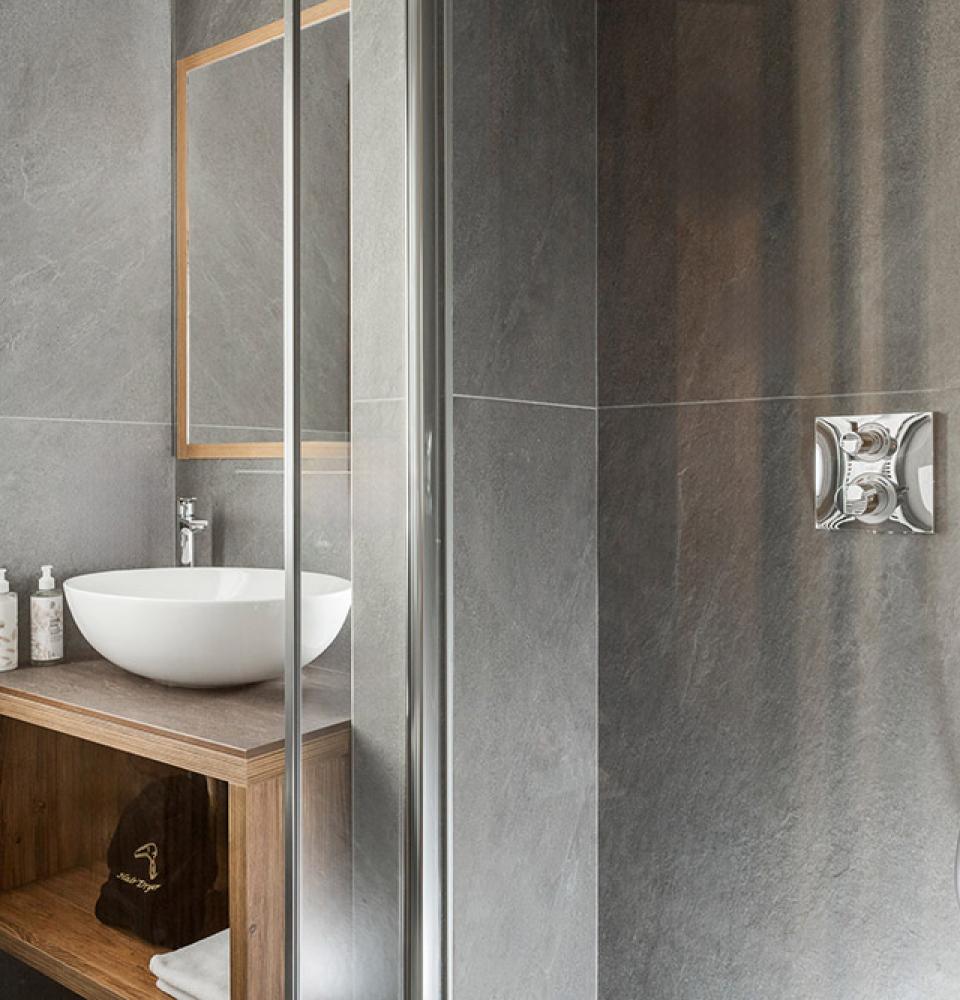 Salle de bain moderne avec lavabo rond et douche.