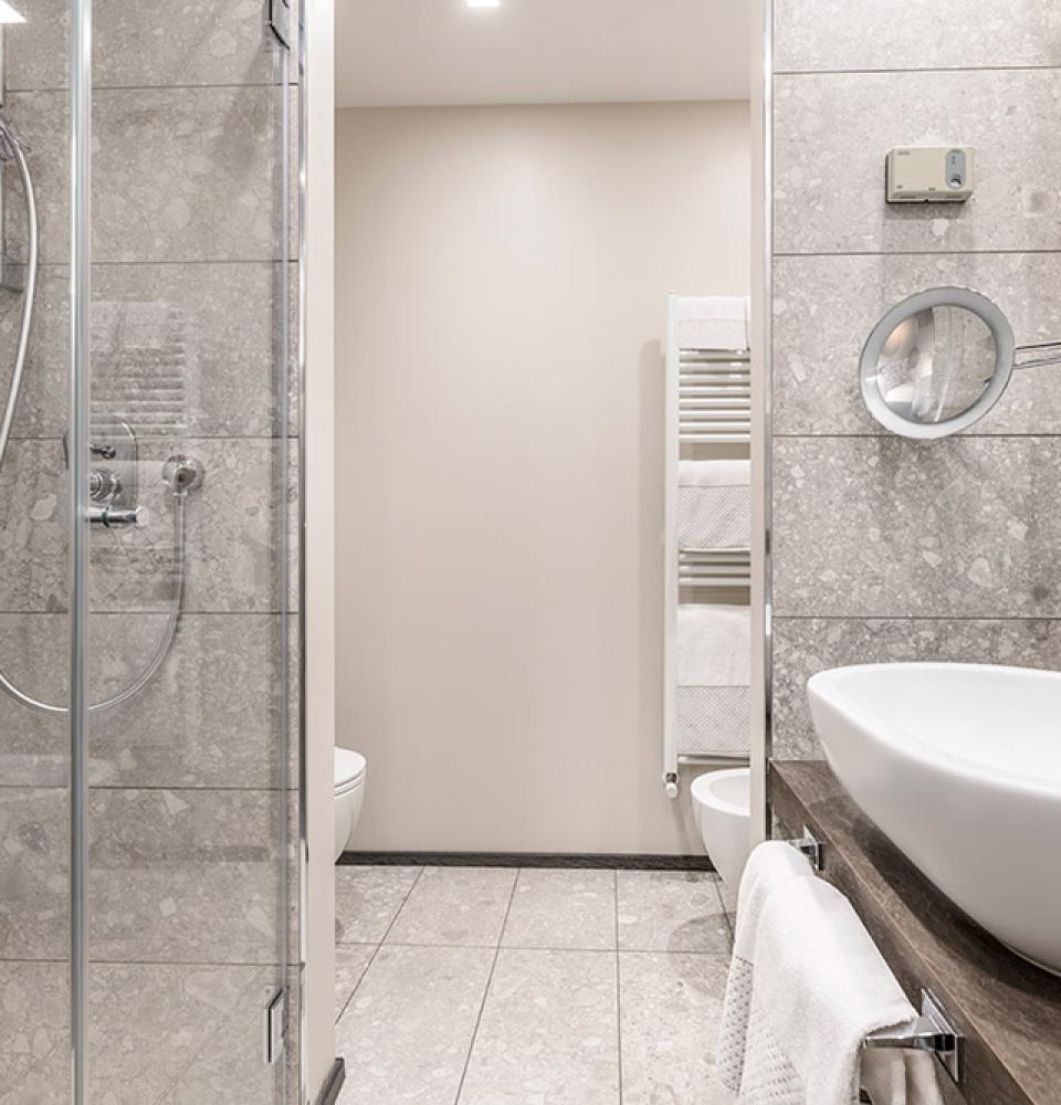 Salle de bain moderne avec douche en verre et lavabo élégant.