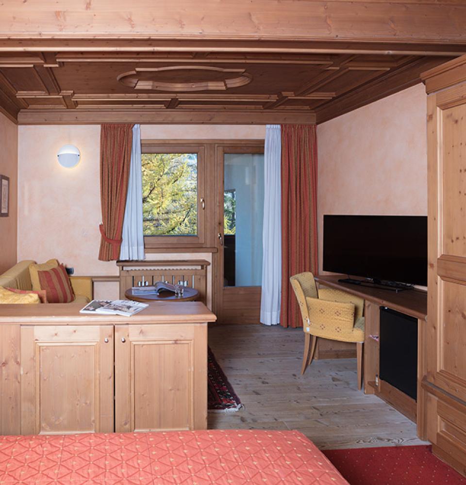 Chambre accueillante avec meubles en bois et TV.