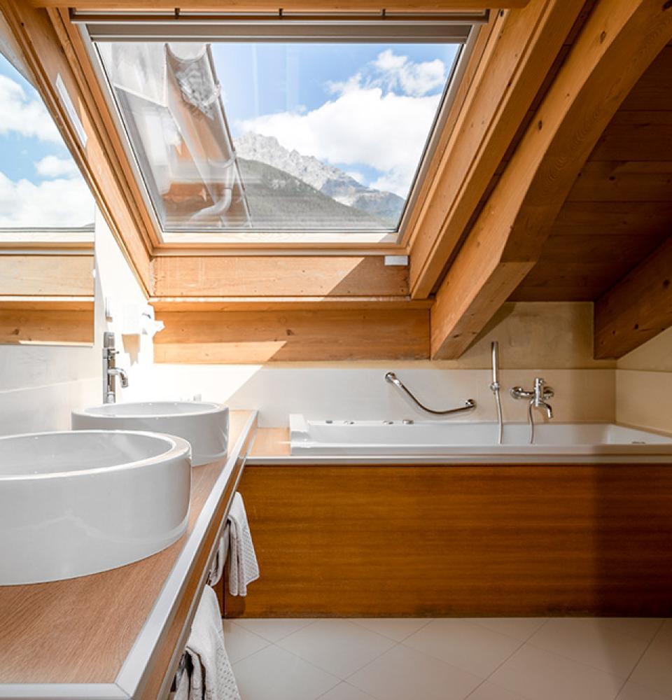 Salle de bain moderne avec lucarne, double vasque et baignoire.