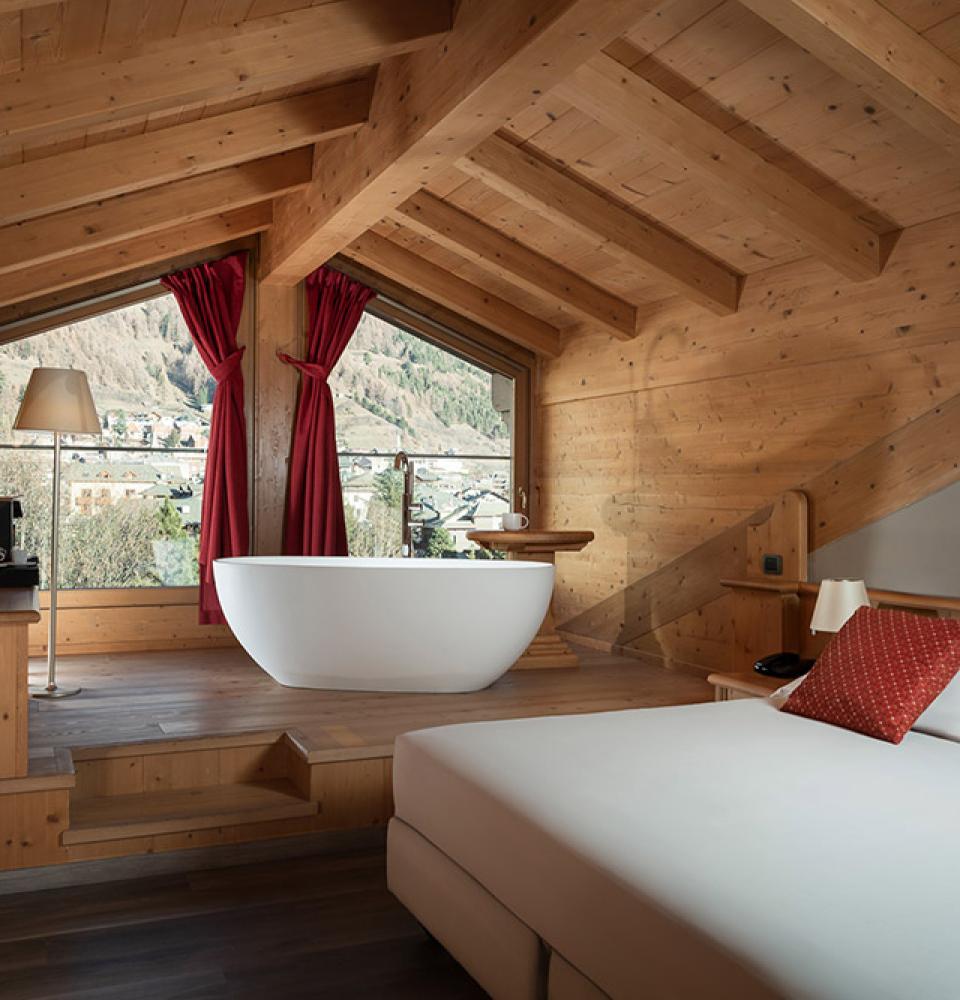 Chambre chaleureuse avec baignoire panoramique et vue sur montagne.