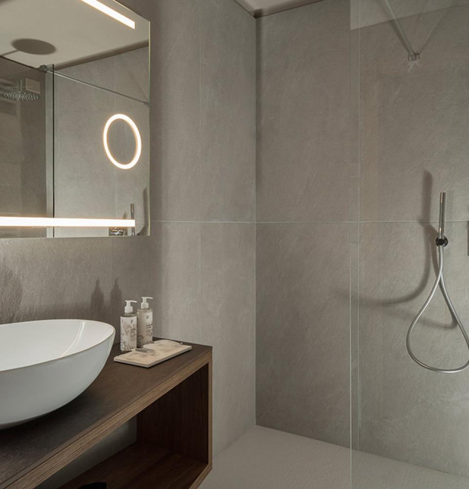 Salle de bain moderne avec lavabo ovale et douche élégante.